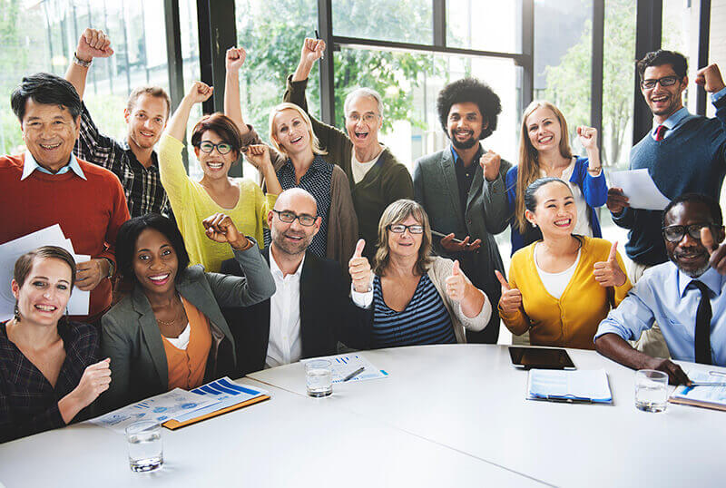 cheering employees around a table