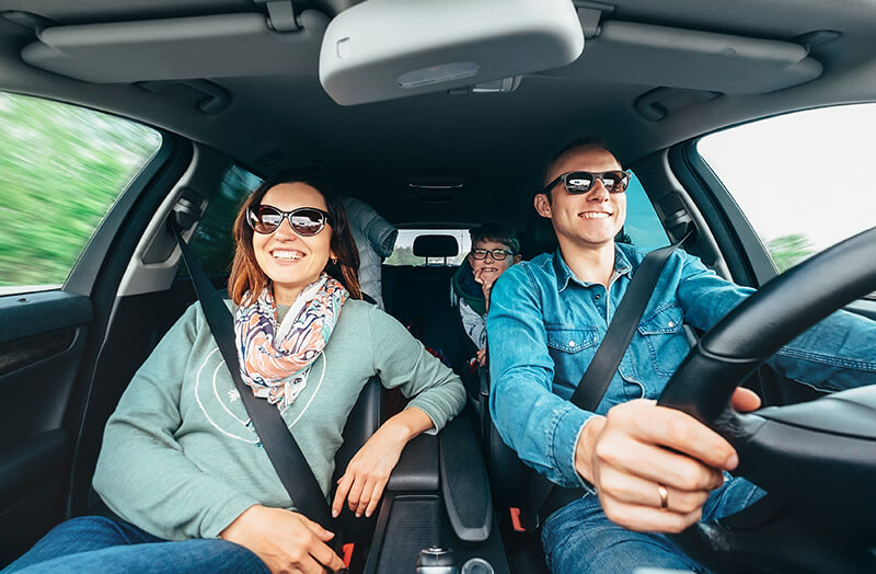 smiling family driving in car