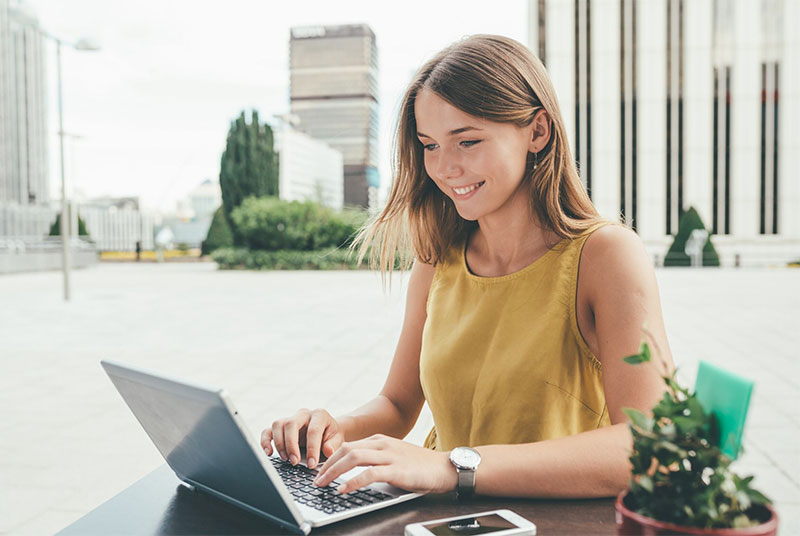 smiling teen using a laptop