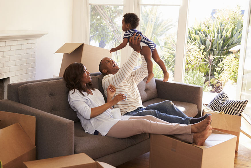 happy family in living room with cardboard boxes