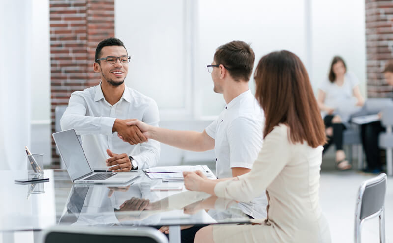 shaking hands at a glass table