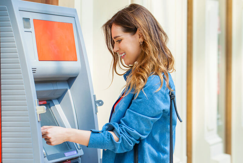 woman in jean jacket at ATM