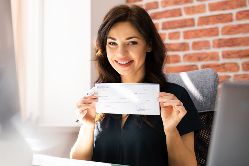 smiling woman holding a check